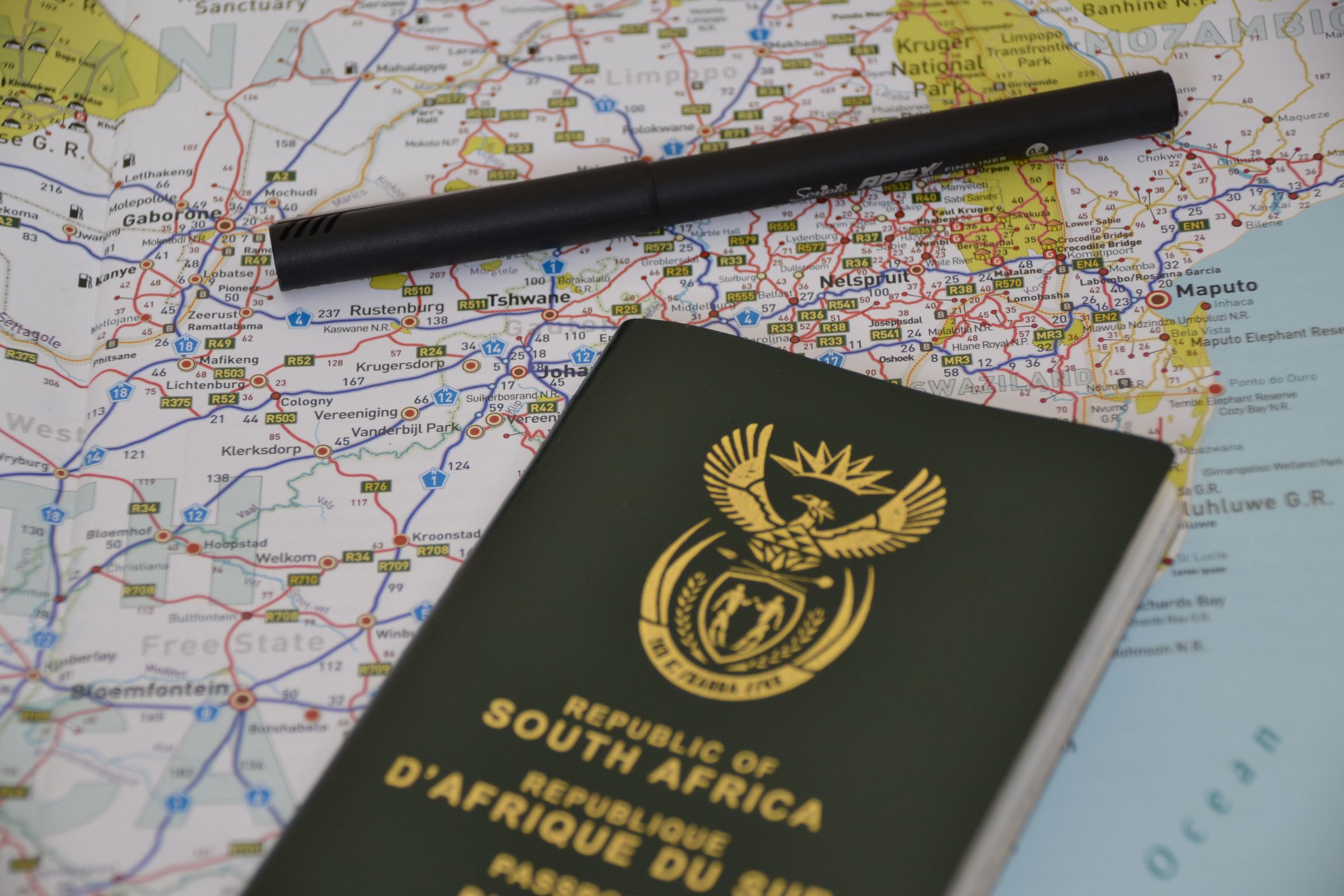 A South African passport resting on a map of South Africa